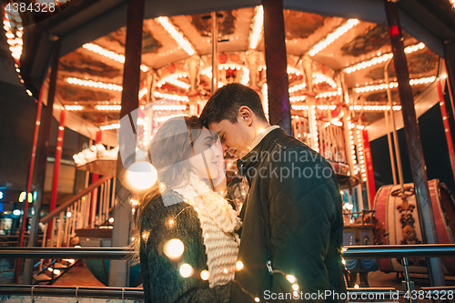 Image of Young couple kissing and hugging outdoor in night street at christmas time