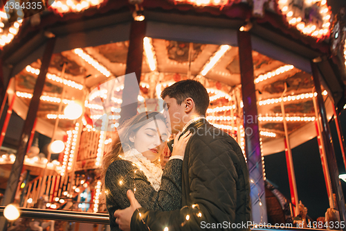 Image of Young couple kissing and hugging outdoor in night street at christmas time