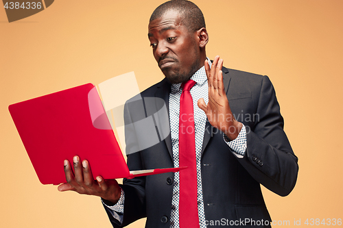 Image of Handsome Afro American man sitting and using a laptop