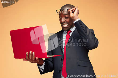 Image of Handsome Afro American man sitting and using a laptop