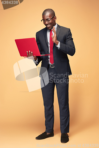 Image of Handsome Afro American man sitting and using a laptop