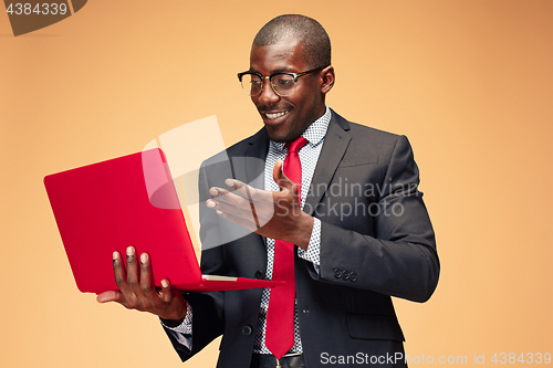 Image of Handsome Afro American man sitting and using a laptop