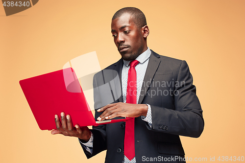 Image of Handsome Afro American man sitting and using a laptop