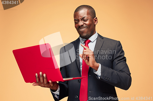 Image of Handsome Afro American man sitting and using a laptop