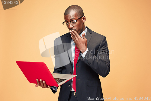 Image of Handsome Afro American man sitting and using a laptop