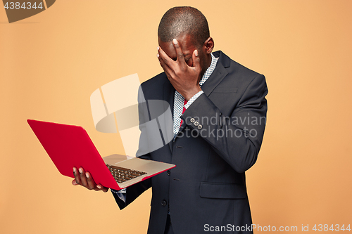 Image of Handsome Afro American man sitting and using a laptop