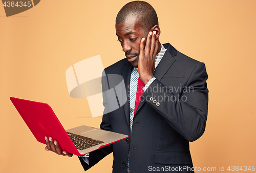 Image of Handsome Afro American man sitting and using a laptop