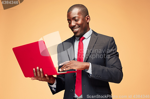 Image of Handsome Afro American man sitting and using a laptop