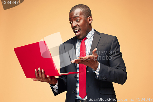 Image of Handsome Afro American man sitting and using a laptop
