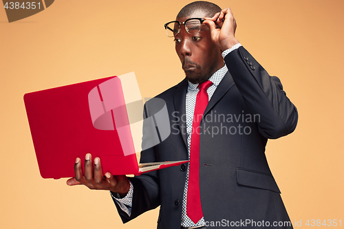 Image of Handsome Afro American man sitting and using a laptop