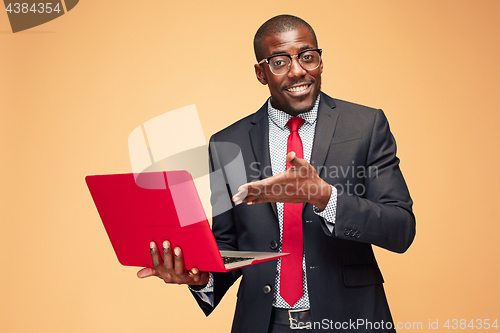 Image of Handsome Afro American man sitting and using a laptop