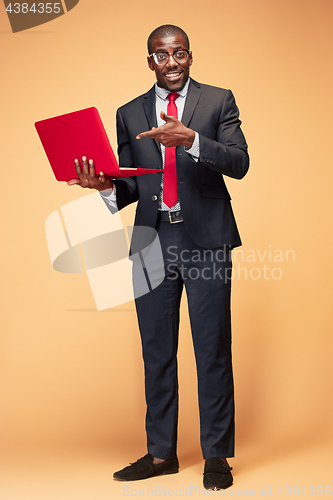 Image of Handsome Afro American man sitting and using a laptop