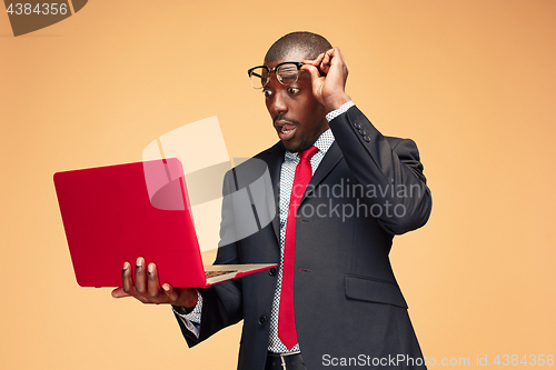 Image of Handsome Afro American man sitting and using a laptop