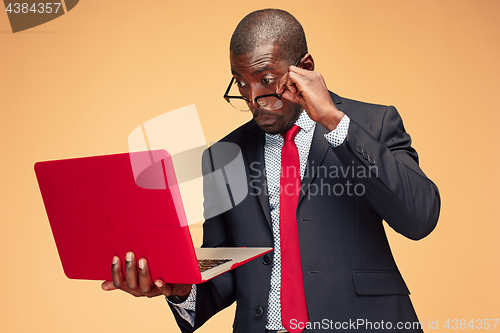 Image of Handsome Afro American man sitting and using a laptop