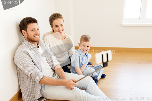 Image of family taking selfie by smartphone at new home