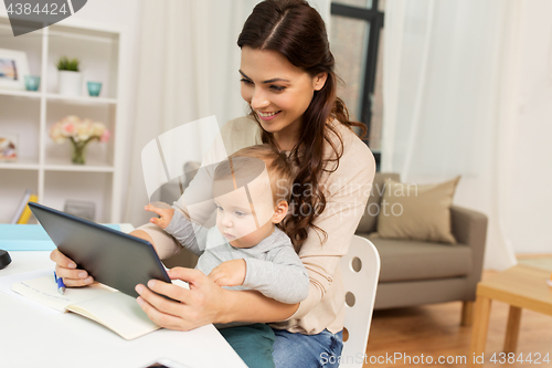 Image of mother student with baby and tablet pc at home