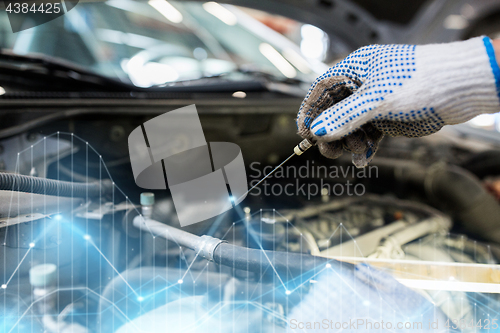 Image of mechanic with dipstick checking motor oil level