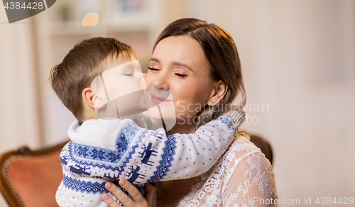 Image of happy little son kissing his mother