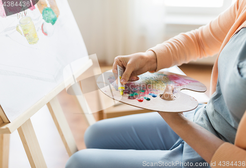 Image of artist applying paint to palette at art studio