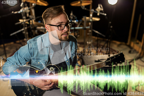 Image of musician playing guitar at studio rehearsal