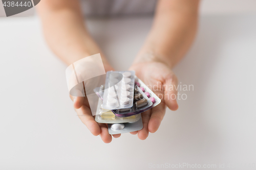 Image of woman hands holding packs of pills