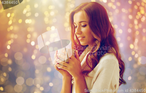 Image of happy woman with cup of tea or coffee at home