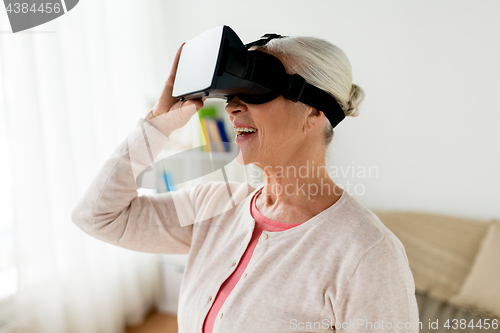 Image of old woman in virtual reality headset or 3d glasses