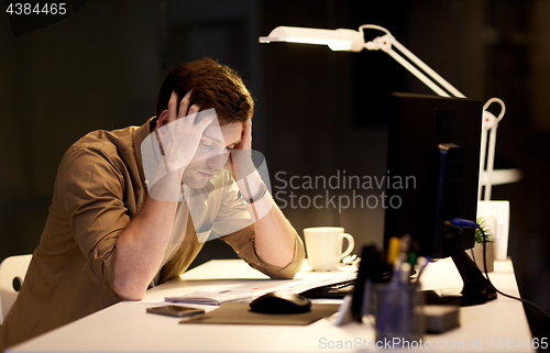 Image of man with computer working late at night office