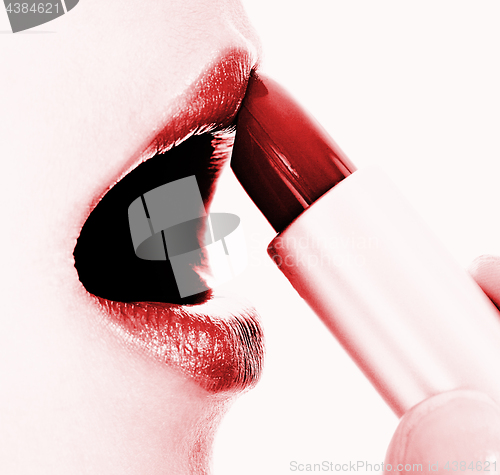 Image of Applying Red Glossy Lipstick To Her Lips