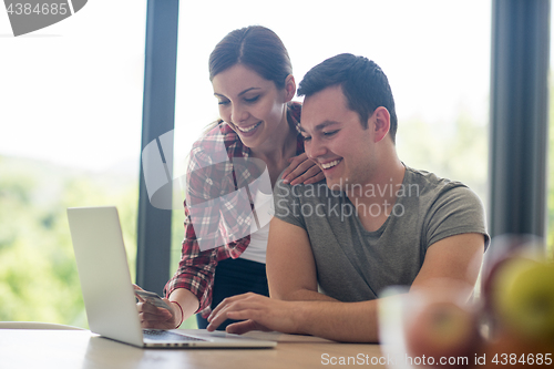 Image of happy young couple buying online