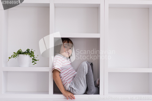 Image of young boy posing on a shelf