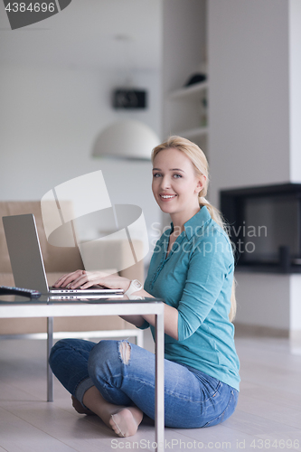 Image of young women using laptop computer on the floor