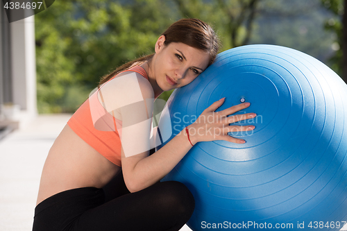 Image of woman doing exercise with pilates ball