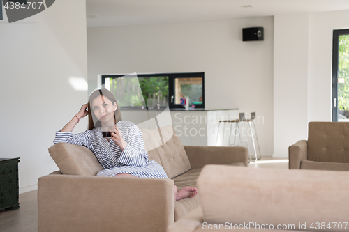 Image of young woman in a bathrobe enjoying morning coffee