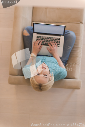 Image of Young woman using laptop at home top view
