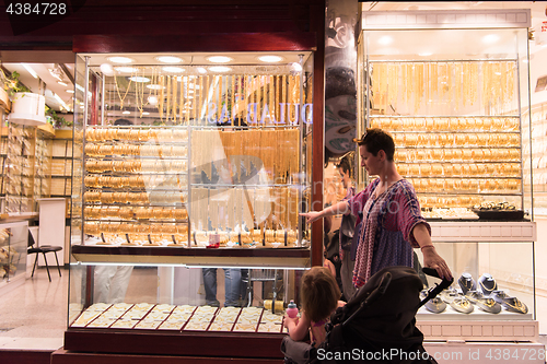 Image of mother with  little girl in a stroller in front of  jewelry shop