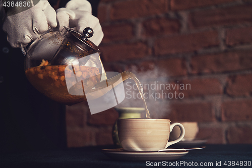 Image of Pouring tea with sea buckthorn