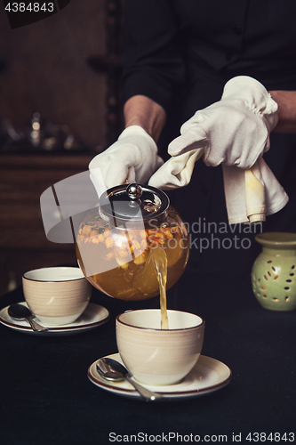 Image of Pouring tea with sea buckthorn