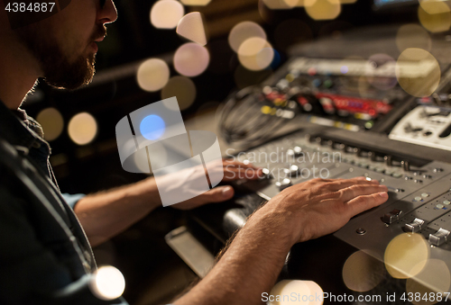 Image of man using mixing console in music recording studio