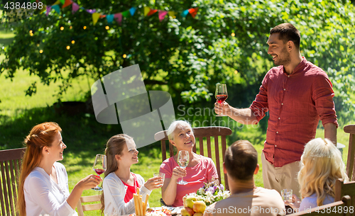 Image of happy family having dinner or summer garden party