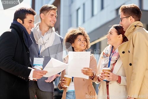 Image of international business team with papers outdoors