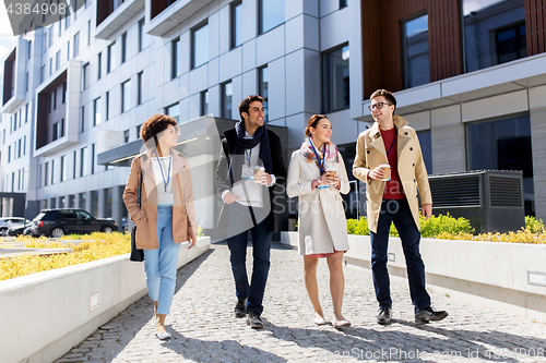 Image of people with coffee and conference badges in city