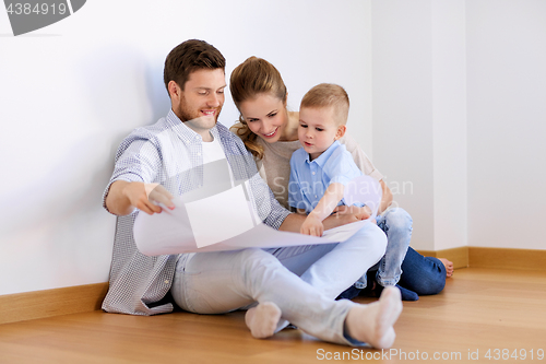 Image of happy family with blueprint moving to new home