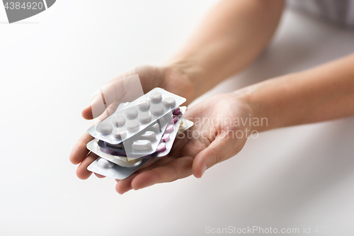 Image of woman hands holding packs of pills