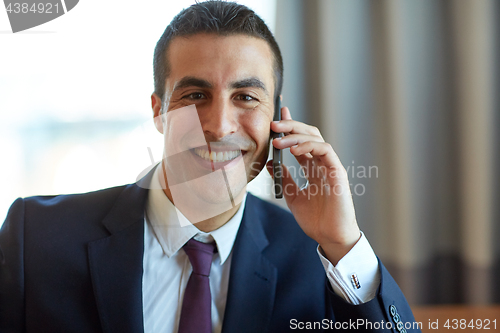 Image of businessman calling on smartphone at hotel room