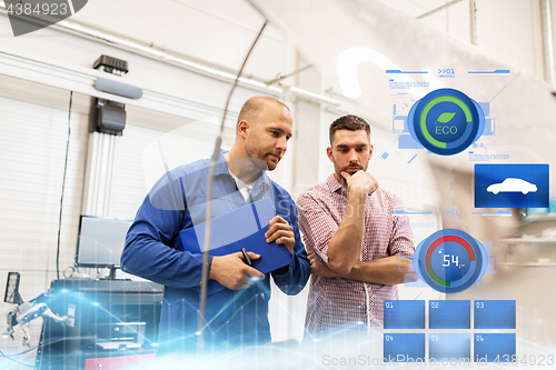 Image of auto mechanic with clipboard and man at car shop