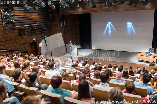 Image of Business speaker giving a talk in conference hall.