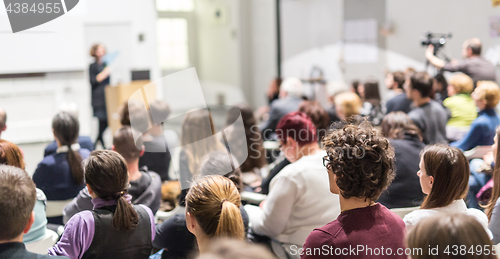 Image of Woman giving presentation in lecture hall at university.