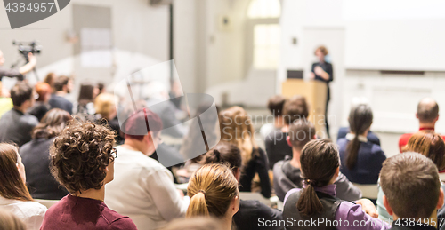 Image of Woman giving presentation in lecture hall at university.