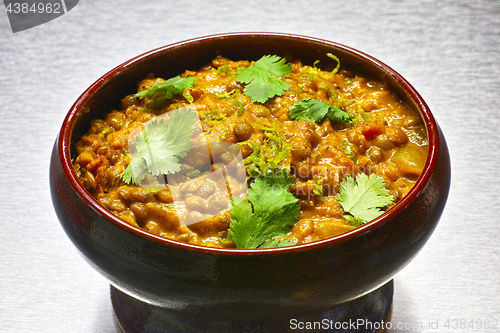 Image of Moong Dal, indian vegetarian lentil soup in terra cotta bowl.